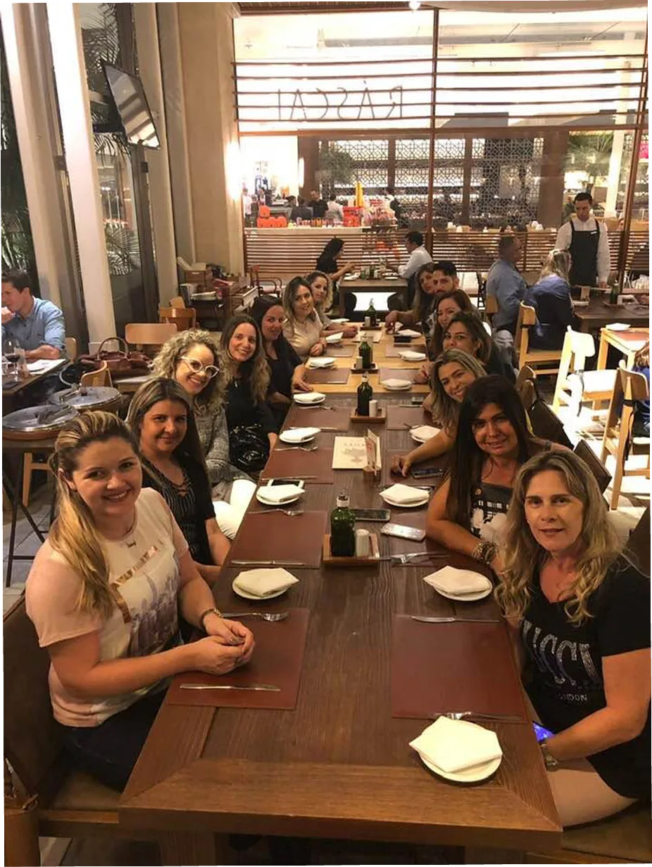 Bell Nacif com equipe em mesa de restaurante.