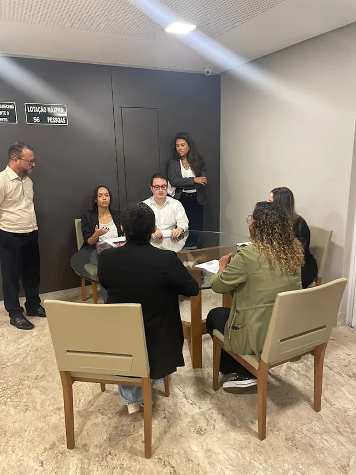 Participantes em reunião de treinamento ao redor da mesa.